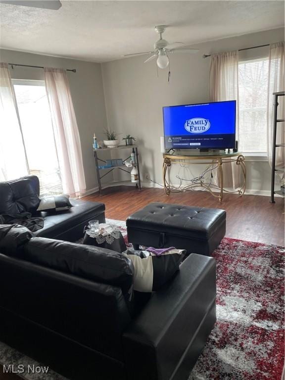 living area featuring a wealth of natural light, ceiling fan, and wood finished floors