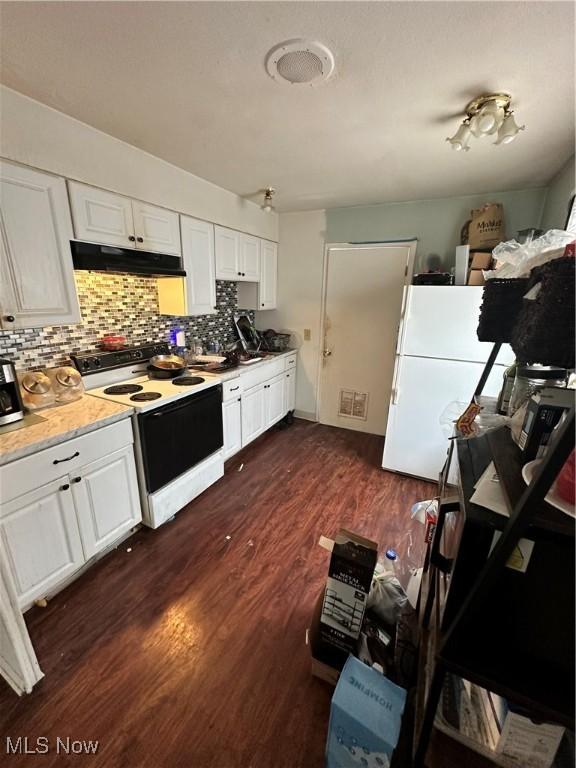 kitchen featuring white appliances, decorative backsplash, dark wood-style floors, under cabinet range hood, and white cabinetry