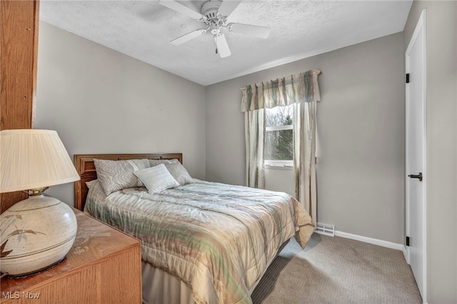 carpeted bedroom with a textured ceiling, visible vents, a ceiling fan, and baseboards