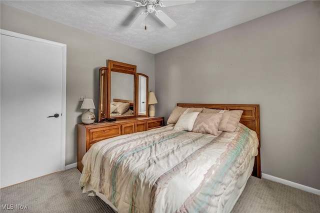 bedroom featuring light colored carpet, a textured ceiling, and baseboards