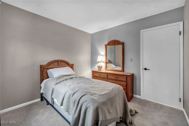 bedroom featuring light colored carpet and baseboards