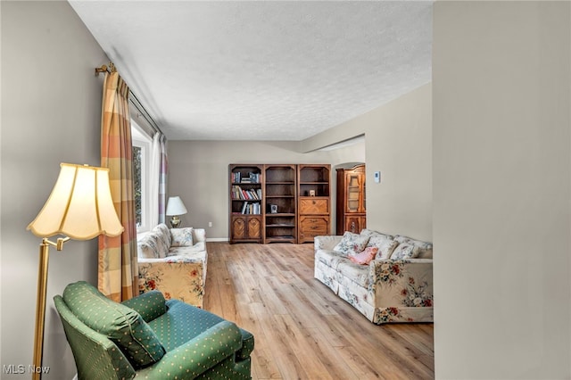 living area with a textured ceiling and wood finished floors