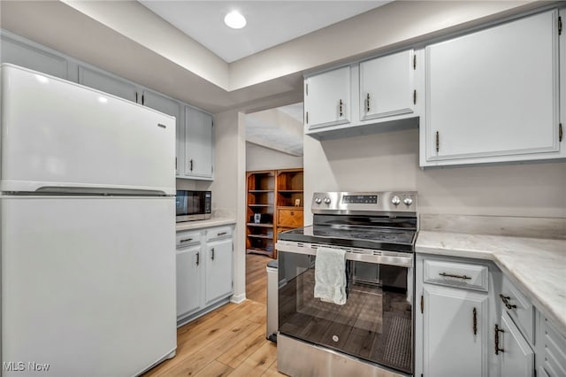 kitchen with light wood-style flooring, freestanding refrigerator, light countertops, stainless steel range with electric cooktop, and recessed lighting