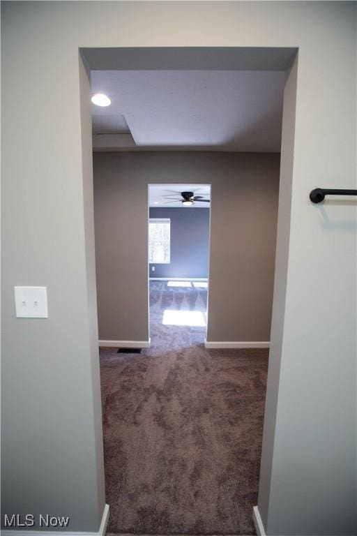 corridor featuring carpet flooring and baseboards