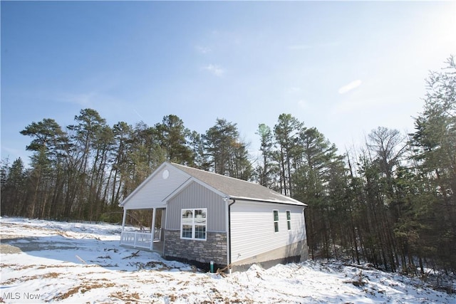 exterior space featuring stone siding and covered porch