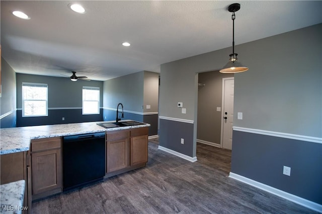 kitchen with dark wood-style floors, light countertops, a sink, dishwasher, and baseboards