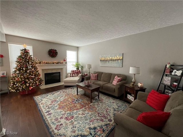 living room featuring a textured ceiling, wood finished floors, and a high end fireplace