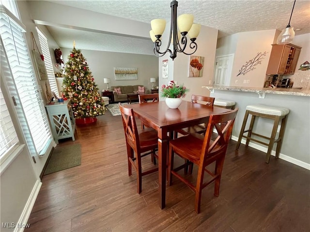 dining room with dark wood-style floors, a notable chandelier, a textured ceiling, and baseboards