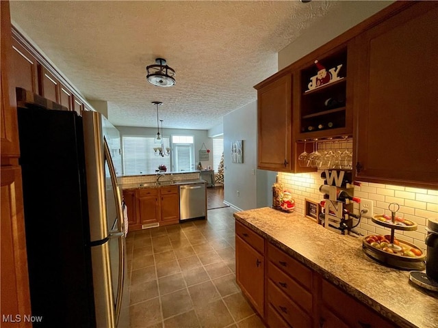 kitchen with appliances with stainless steel finishes, decorative light fixtures, light countertops, open shelves, and backsplash