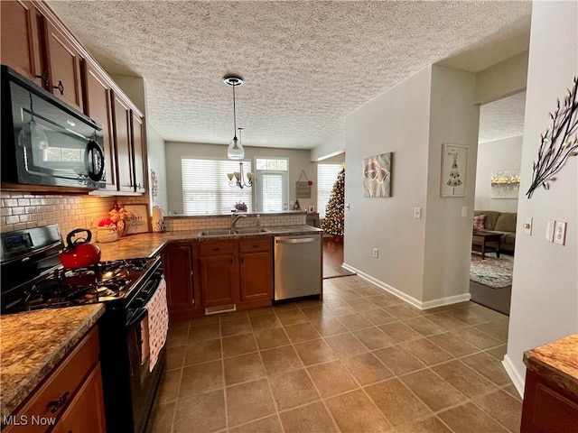 kitchen featuring tasteful backsplash, stainless steel dishwasher, gas stove, a sink, and black microwave