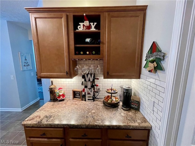 bar with tasteful backsplash and baseboards