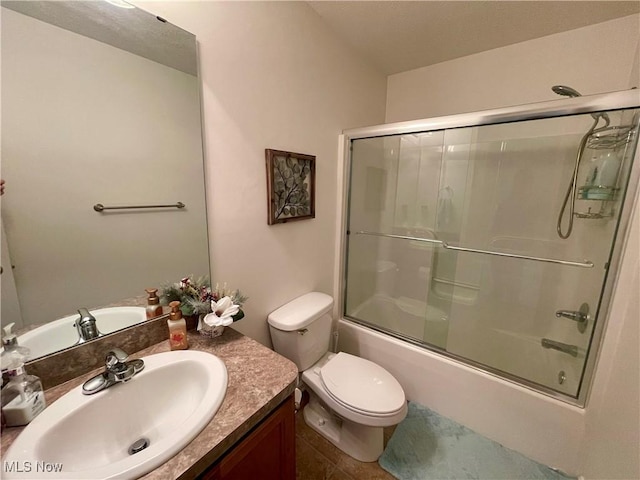 bathroom featuring combined bath / shower with glass door, vanity, and toilet