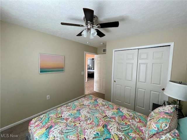 bedroom with carpet, a closet, baseboards, and a textured ceiling