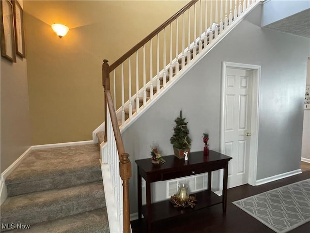 stairs featuring a high ceiling and baseboards