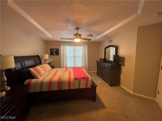 bedroom featuring baseboards, visible vents, ornamental molding, a tray ceiling, and a textured ceiling