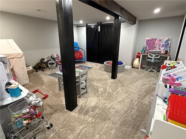 playroom with a barn door and carpet flooring