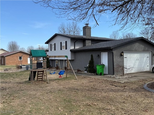 back of house with a playground, a garage, brick siding, roof with shingles, and a chimney