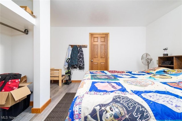 bedroom with wood finished floors and baseboards