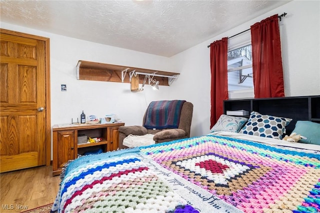 bedroom featuring a textured ceiling and wood finished floors