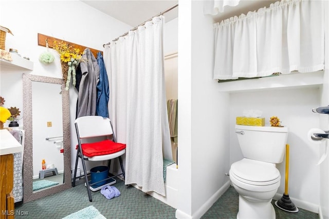 bathroom with toilet, curtained shower, and baseboards