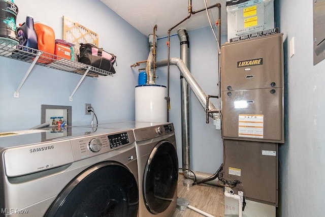 clothes washing area featuring water heater, laundry area, and washing machine and clothes dryer