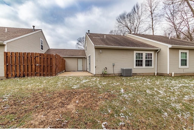 rear view of property with a shingled roof, fence, a yard, central air condition unit, and a patio area