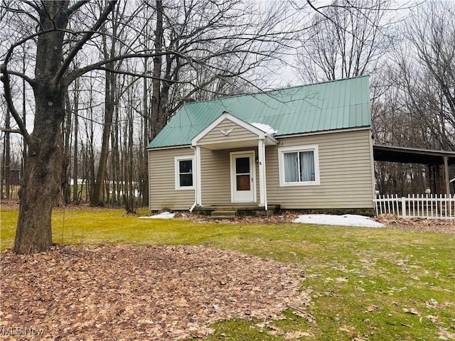 view of front of house with fence, metal roof, and a front yard