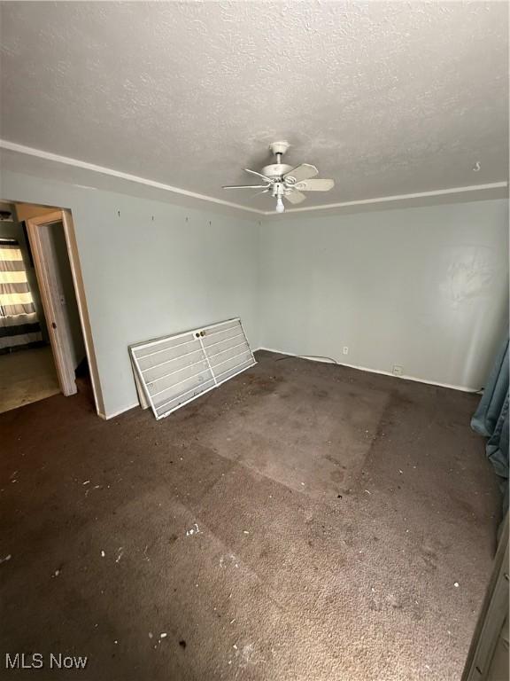 empty room featuring a textured ceiling and a ceiling fan