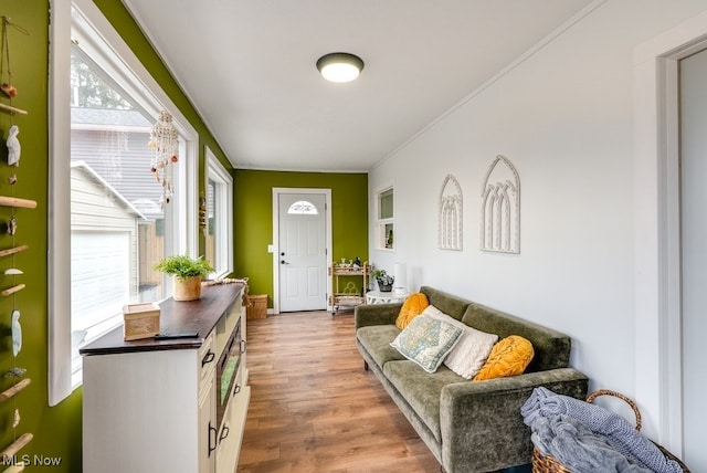 living room with wood finished floors and crown molding