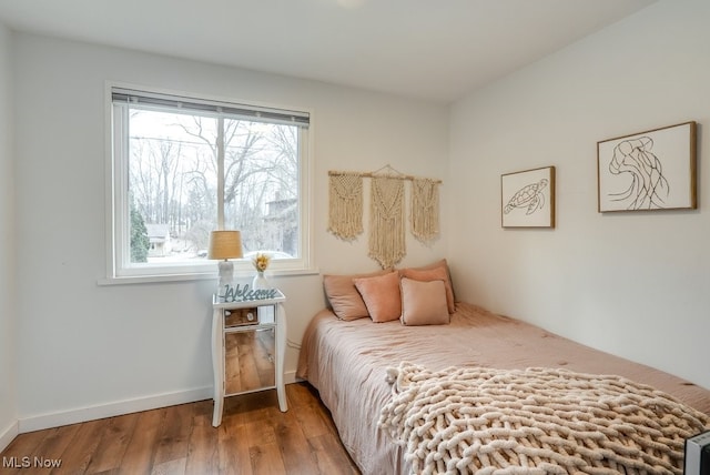 bedroom with baseboards and wood finished floors