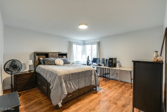 bedroom featuring light wood finished floors and baseboards