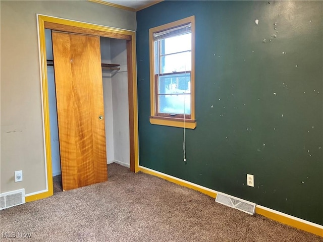 unfurnished bedroom with a closet, baseboards, visible vents, and carpet flooring