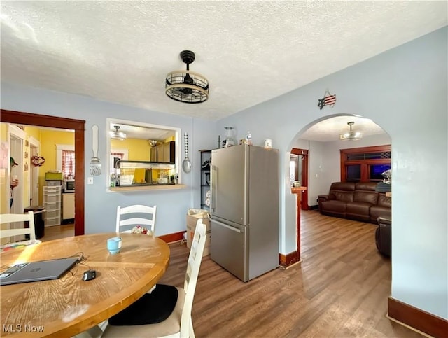 328 Scott Ave, Niles, OH 44446 - dining room featuring arched walkways, wood finished floors, a textured ceiling, and baseboards