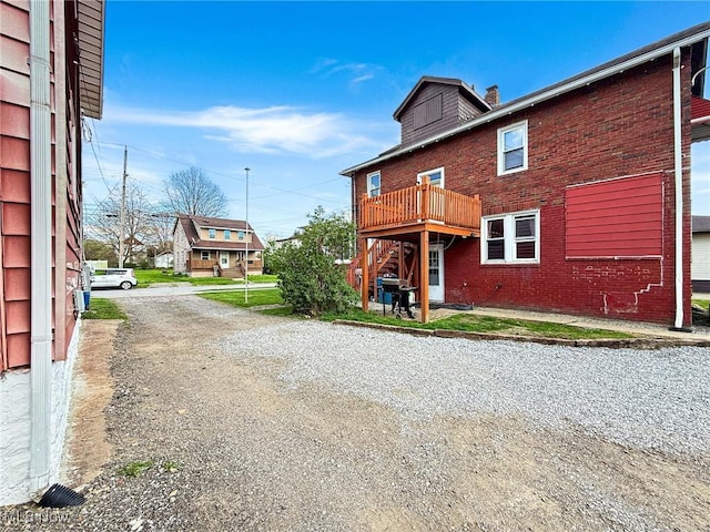 328 Scott Ave, Niles, OH 44446 - back of property featuring a chimney, brick siding, a wooden deck, and stairs