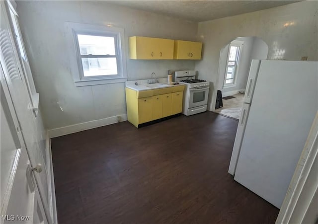 328 Scott Ave, Niles, OH 44446 - kitchen with white appliances, dark wood-type flooring, arched walkways, light countertops, and baseboards