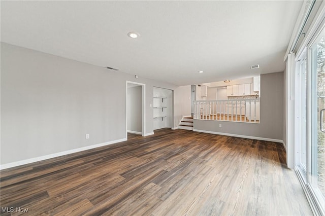 interior space with dark wood-style floors, recessed lighting, visible vents, stairway, and baseboards