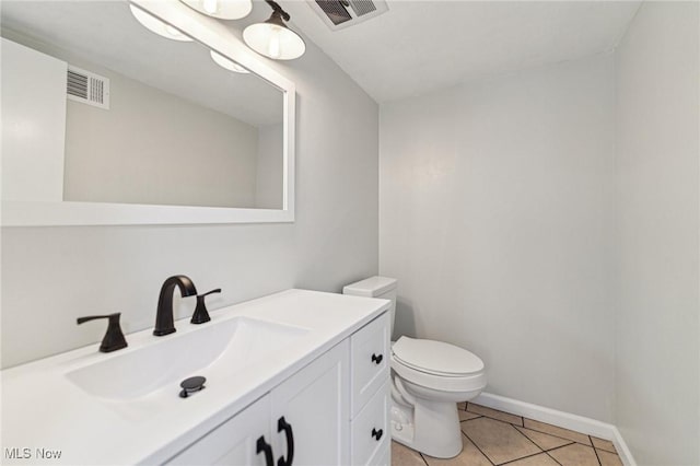 half bathroom featuring tile patterned flooring, visible vents, vanity, and toilet