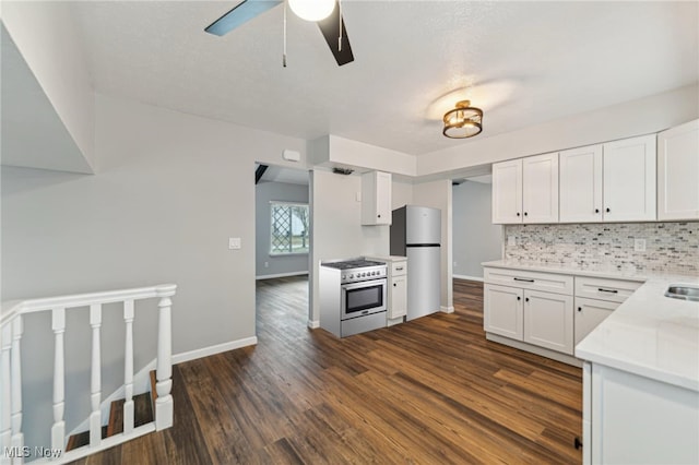 kitchen featuring stainless steel appliances, dark wood-type flooring, white cabinetry, light countertops, and backsplash