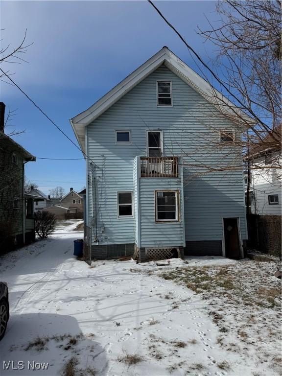 view of snow covered rear of property