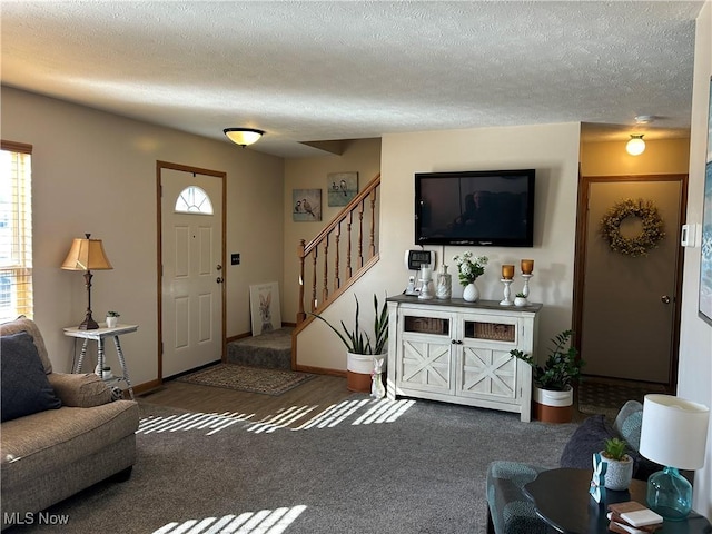 living room with stairs, a textured ceiling, and carpet flooring