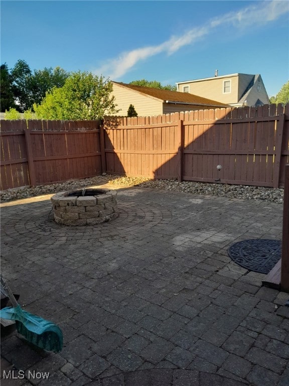 view of yard featuring a patio area, an outdoor fire pit, and fence