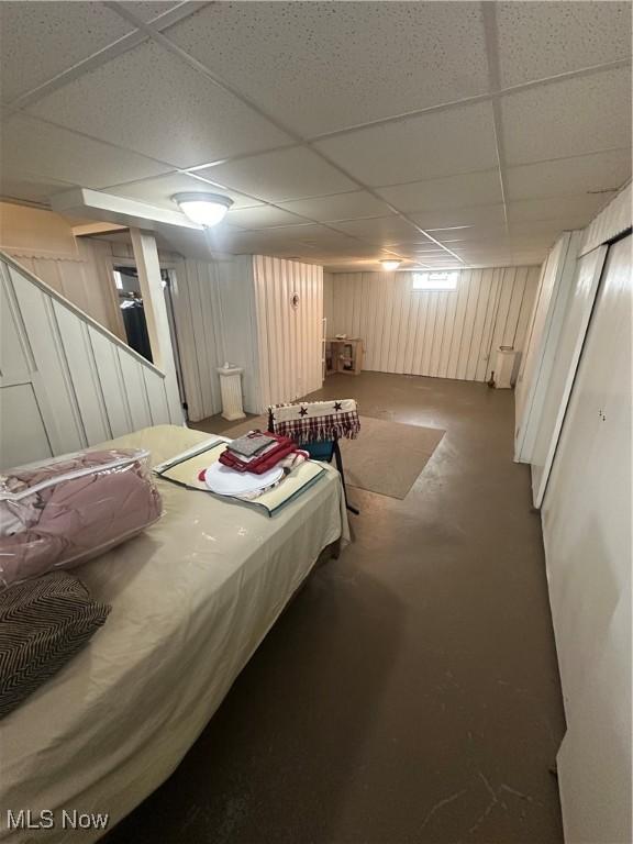 bedroom featuring concrete floors and a drop ceiling