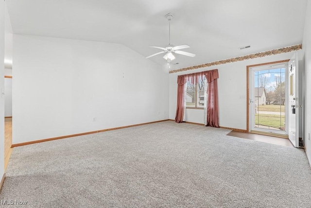 spare room with visible vents, light carpet, vaulted ceiling, ceiling fan, and baseboards