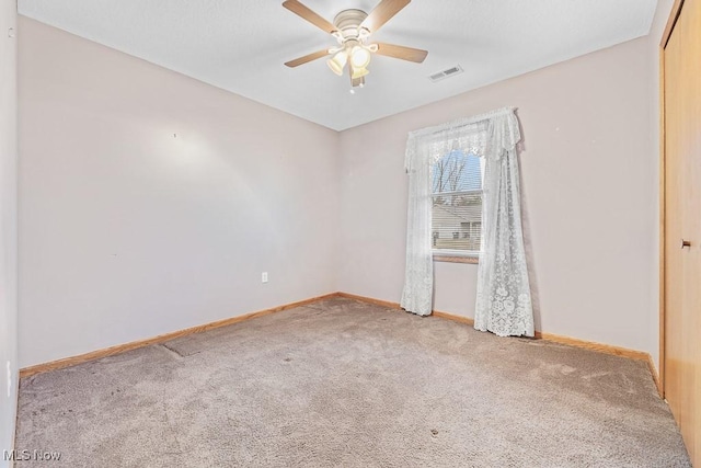 empty room with a ceiling fan, baseboards, visible vents, and carpet flooring