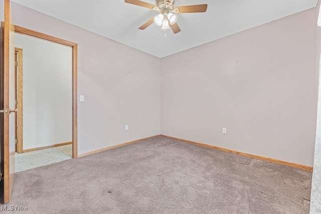 carpeted empty room with ceiling fan and baseboards