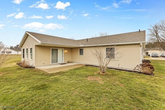 rear view of property with roof with shingles, a lawn, and a patio