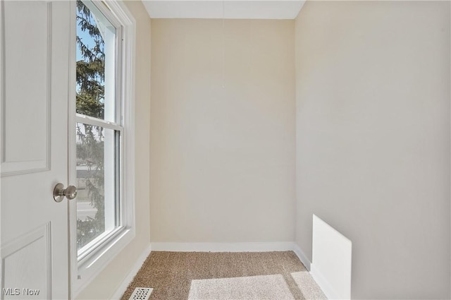 carpeted empty room with visible vents and baseboards