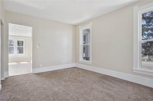 unfurnished room with carpet floors, plenty of natural light, and baseboards