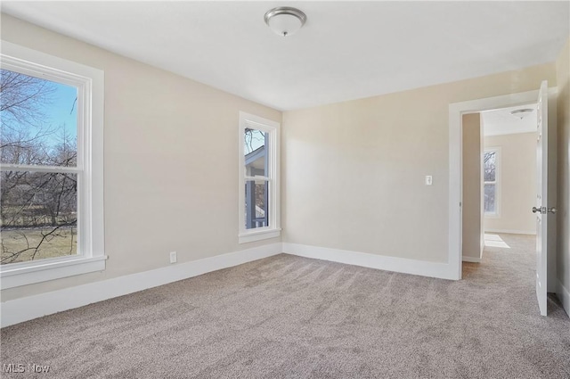 spare room with carpet, plenty of natural light, and baseboards