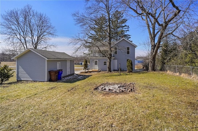 rear view of house featuring a yard, fence, and an outdoor structure